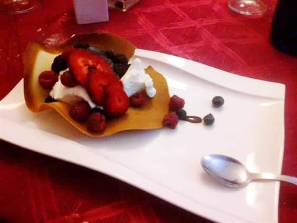 Wafer basket with cream, strawberries and raspberries on white plate