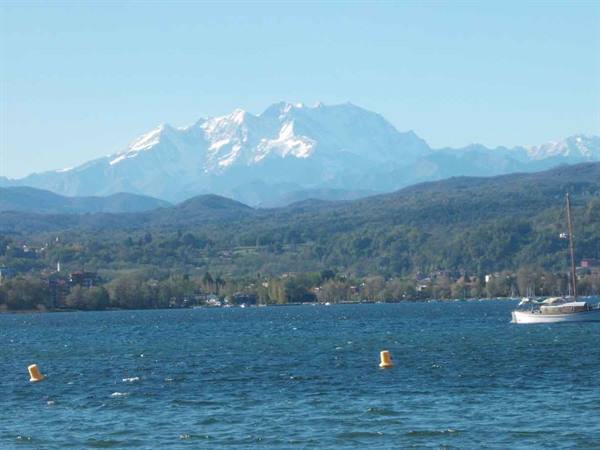 Boats and yellow buoys on the lake, snow-capped Alps behind