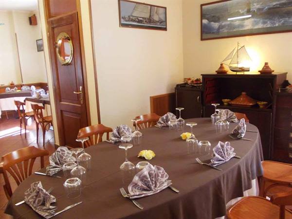 Dining table set with brown cloth, glasses and folded napkins, wooden dining room