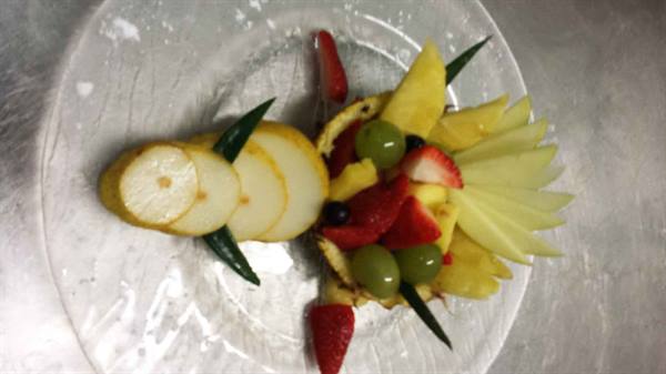 Fruit carved into a fish shape with pineapple, grapes and strawberries