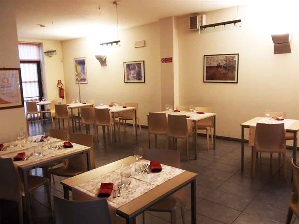 Empty restaurant dining room with set tables, light tablecloths and beige chairs