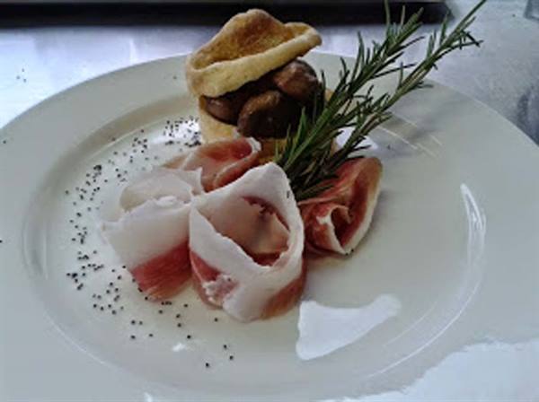 White plate with prosciutto, mushrooms in bread and rosemary sprig