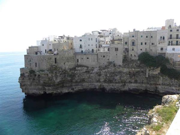 White houses of Polignano a Mare above limestone cliffs over turquoise sea