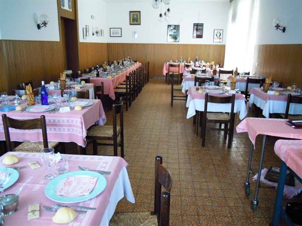 Dining room set with pink tablecloths, wooden chairs and natural light