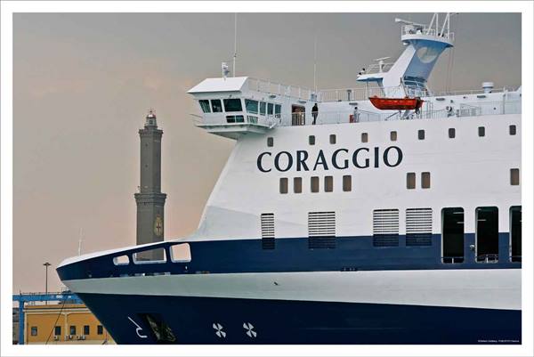 Ferry Coraggio moored at the harbor, Genoa's Lanterna lighthouse behind