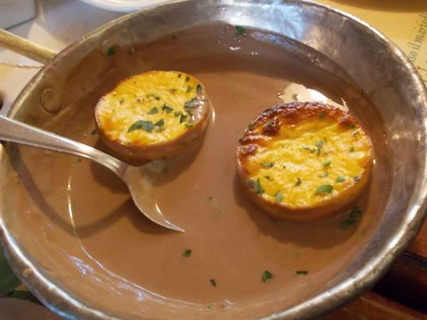 Golden baked patties in copper pan with silver spoon