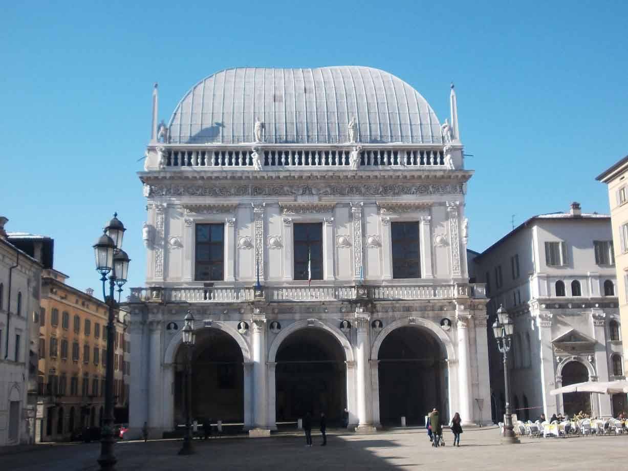 Palazzo della Loggia a Brescia, facciata bianca in pietra sotto cielo azzurro