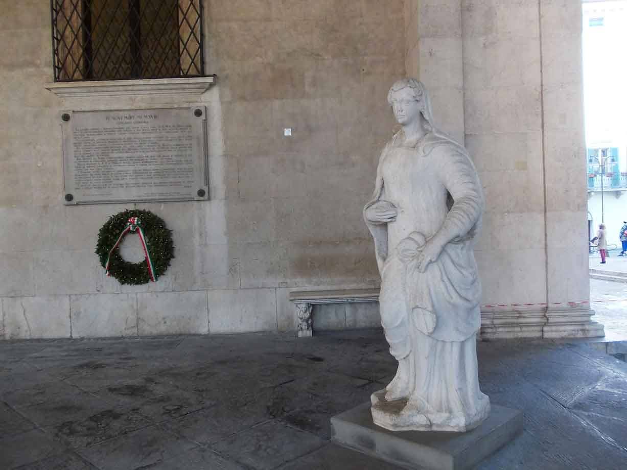 Statua in marmo di donna con corona d'alloro sulla parete della loggia