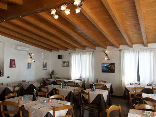 Restaurant dining room with set tables, wooden beam ceiling and natural light