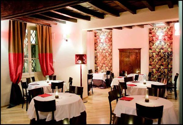 Restaurant dining room with set tables, wooden beams and red curtains