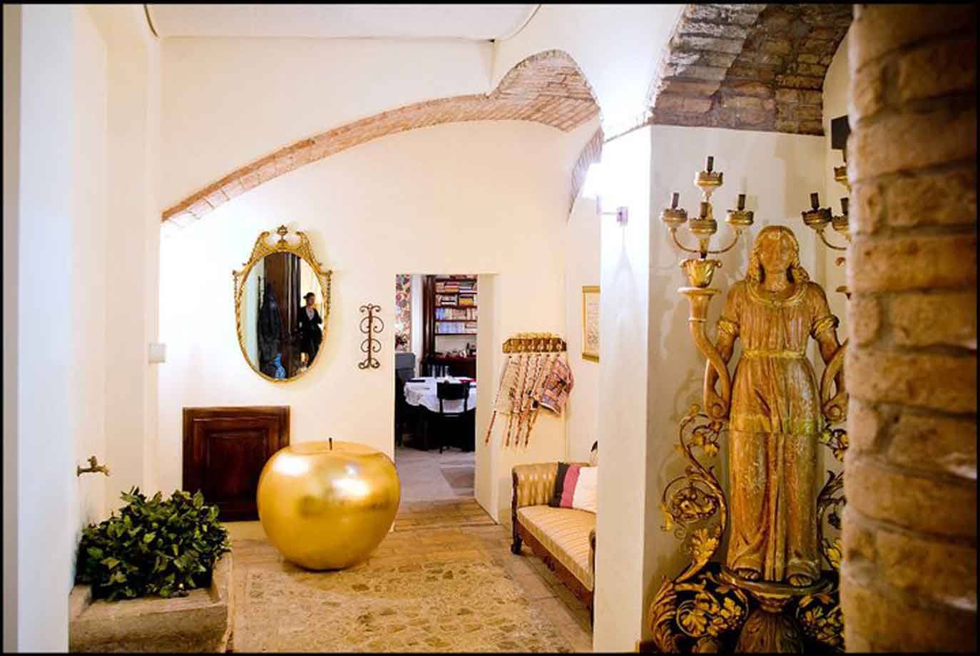 Ingresso con volta in mattoni, mela dorata e statua lignea dorata