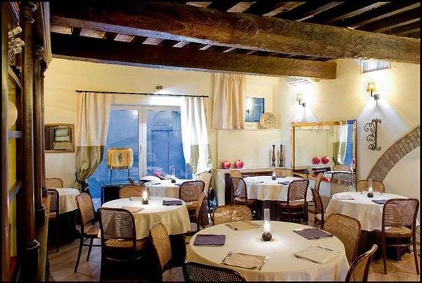 Restaurant dining room with set tables, wicker chairs and wooden beams
