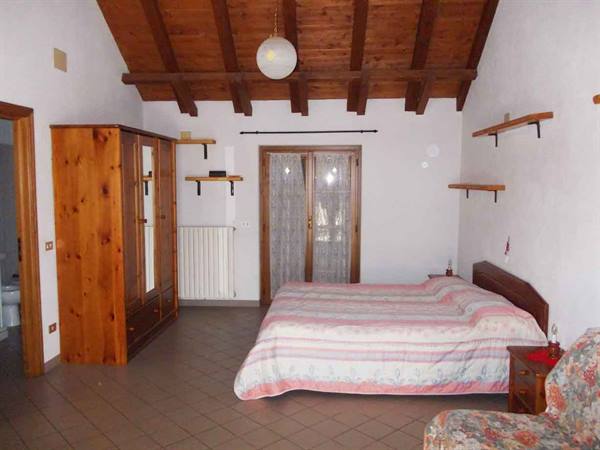 Bedroom with double bed, wooden wardrobe and exposed beam ceiling