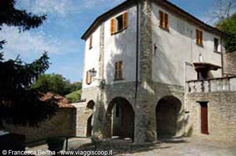 Stone and plaster house with arches and wooden shutters in sunlight
