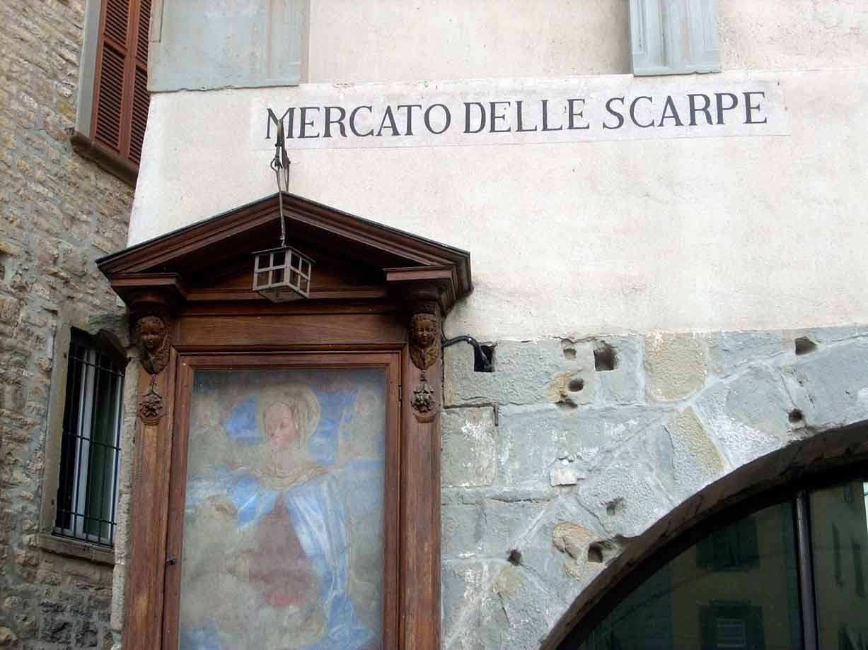 Edicola votiva in legno con affresco sotto la scritta Mercato delle Scarpe