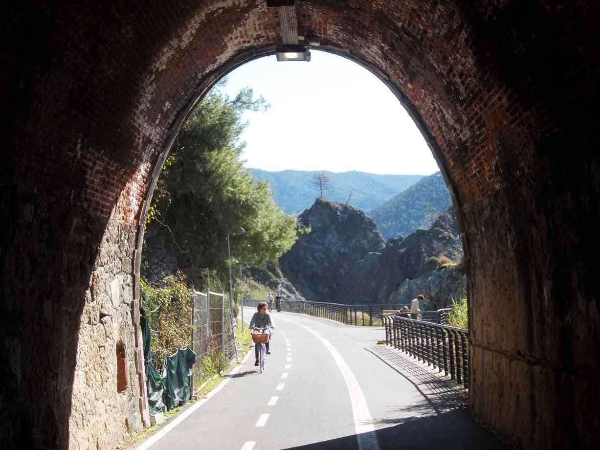 Ciclista esce dal tunnel in mattoni sulla pista ciclabile costiera