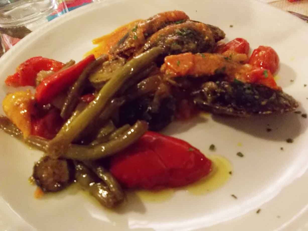 Piatto bianco con verdure grigliate, fagiolini e pomodorini al gazebo