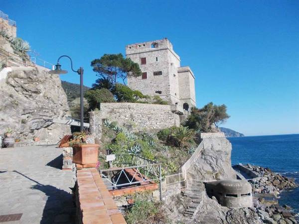Ancient stone tower above the rocks in Monterosso al Mare, blue sky