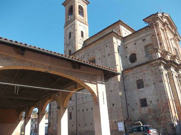 Brick church with bell tower and arched portico under blue sky