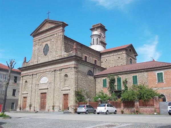 Brick church with pediment facade and bell tower, cars parked on the square