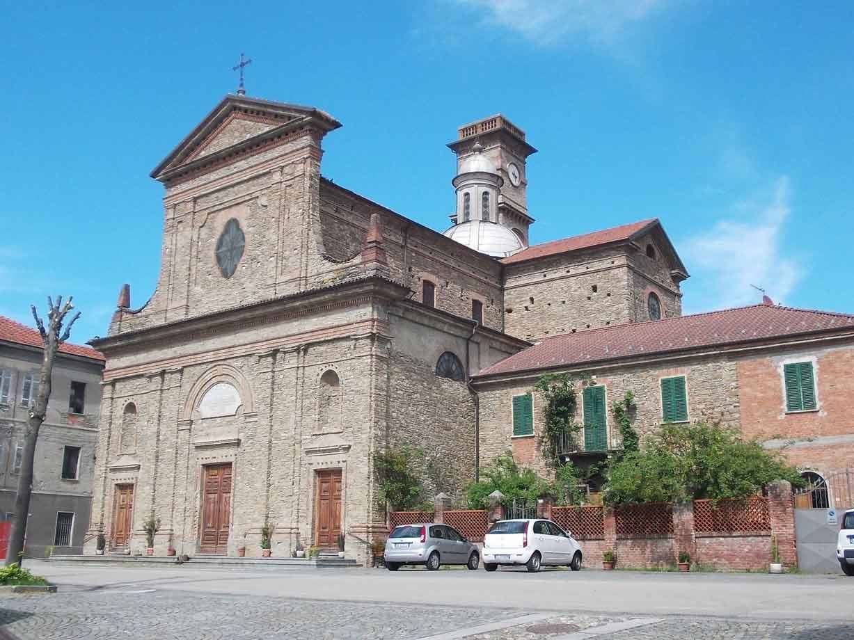 Chiesa in mattoni con facciata a timpano e campanile, auto parcheggiate sulla piazza