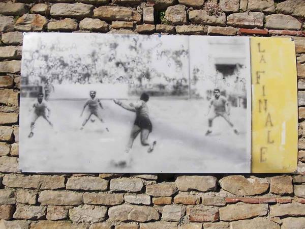 Plaque on stone wall showing black and white football players photo, La Finale