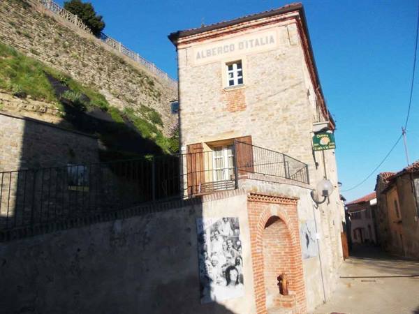 Stone house reading Albenco d'Italia with arched brick fountain in the village