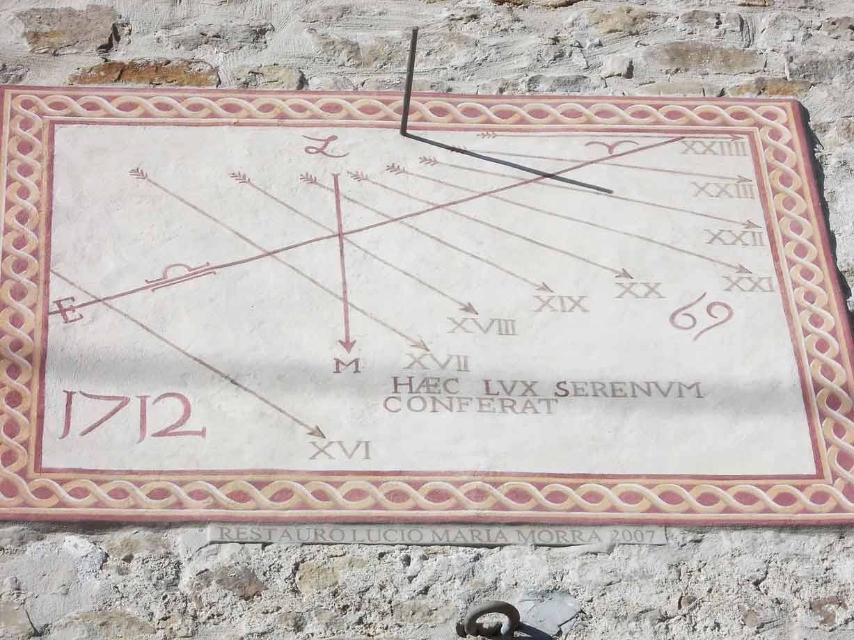 Meridiana affrescata del 1712 su muro di pietra, con scritte in latino