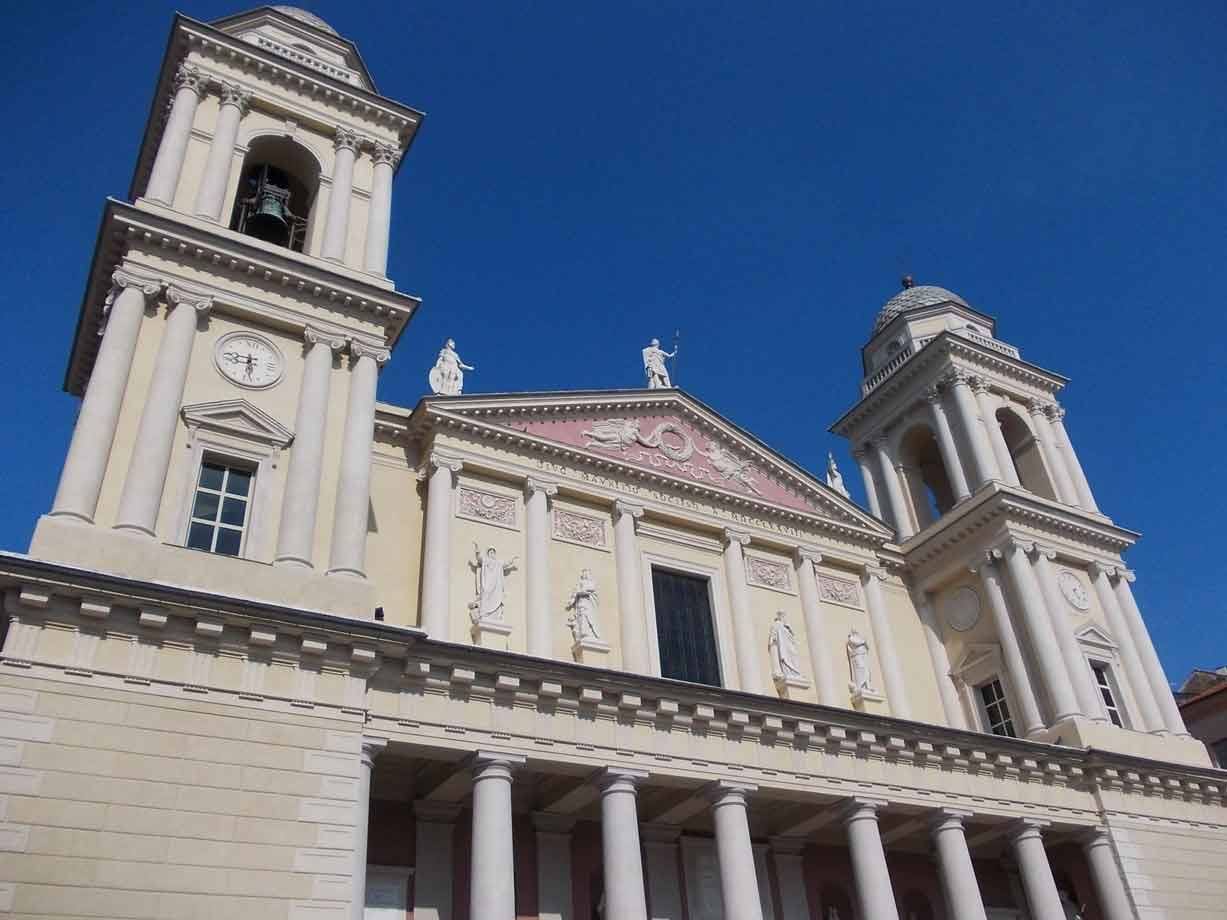 Facciata neoclassica con due campanili, statue e colonne sotto cielo azzurro