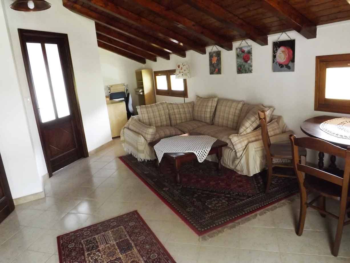 Soggiorno con divano a plaid, travi in legno e tappeti
