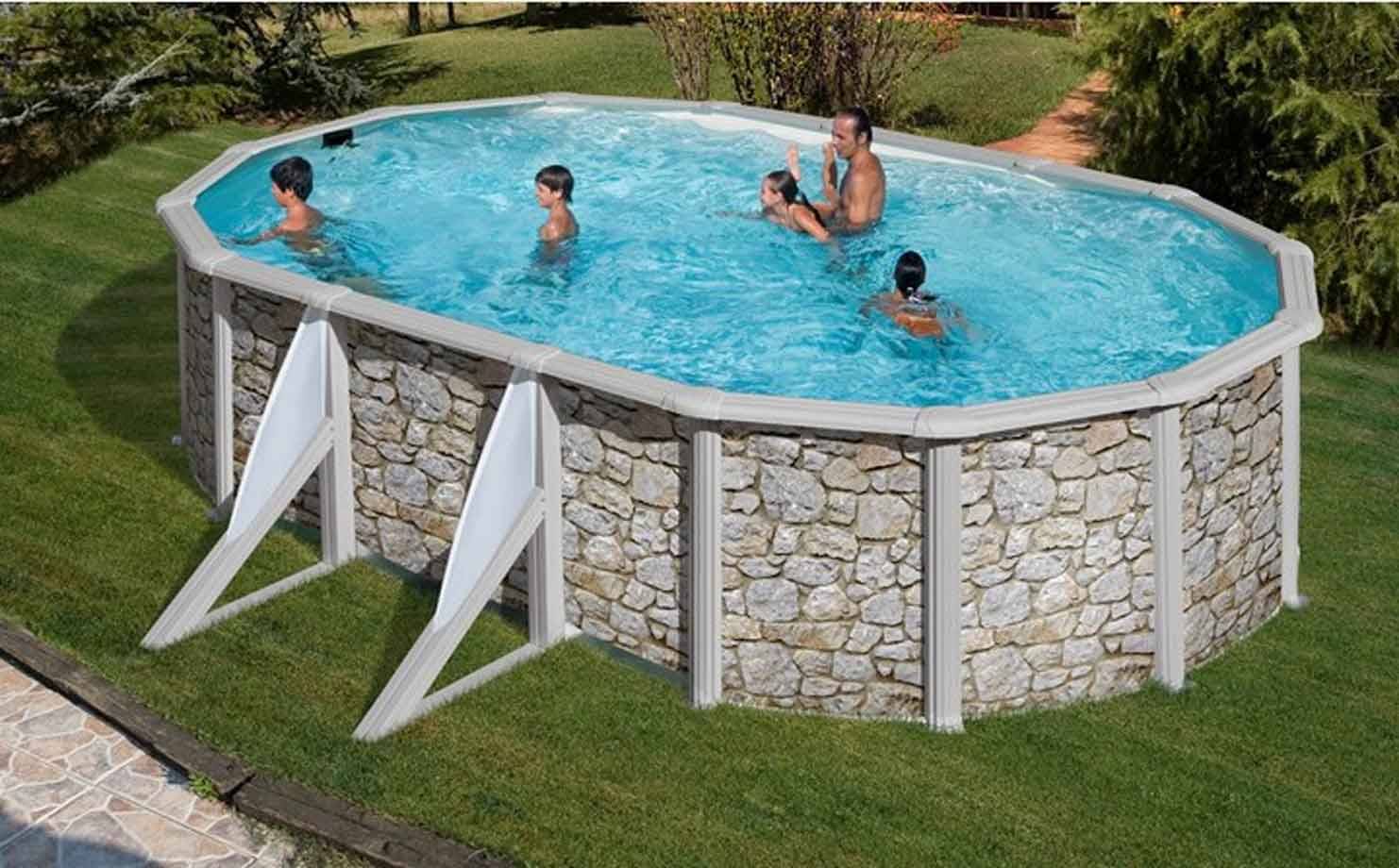 Famiglia nuota in piscina fuori terra ovale effetto pietra, su prato verde