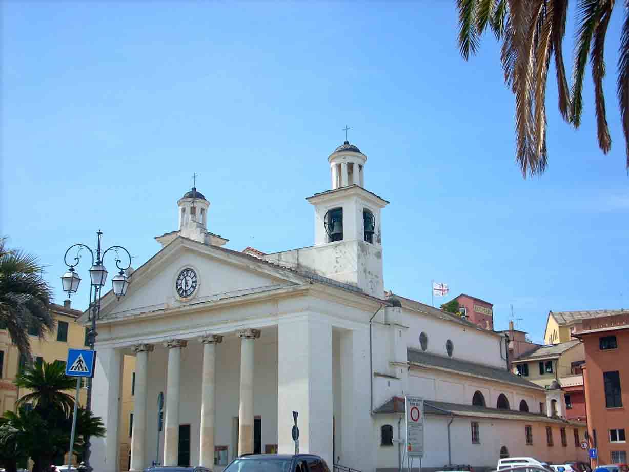 Chiesa bianca neoclassica con colonne e campanile, palme e cielo azzurro