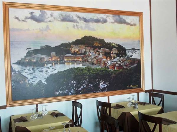 Framed painting of a harbor with boats above set restaurant tables