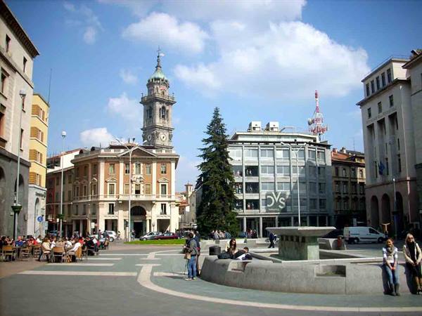 Bergamo square with historic bell tower, stone fountain and sunny outdoor cafés