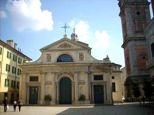 San Vittore church in Varese, classical facade in sunlight, people crossing the square