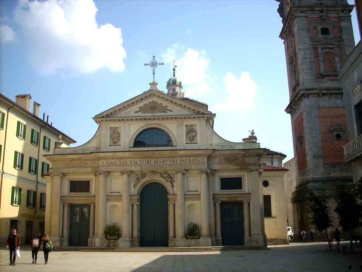 Chiesa di San Vittore a Varese, facciata classica illuminata dal sole, passanti sulla piazza