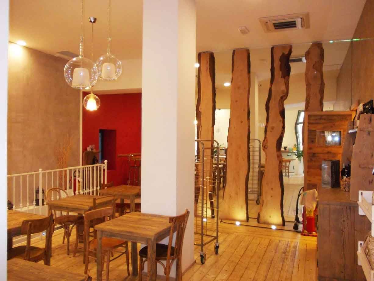 Tavoli in legno e tronchi di legno grezzo come pareti divisorie in un ristorante