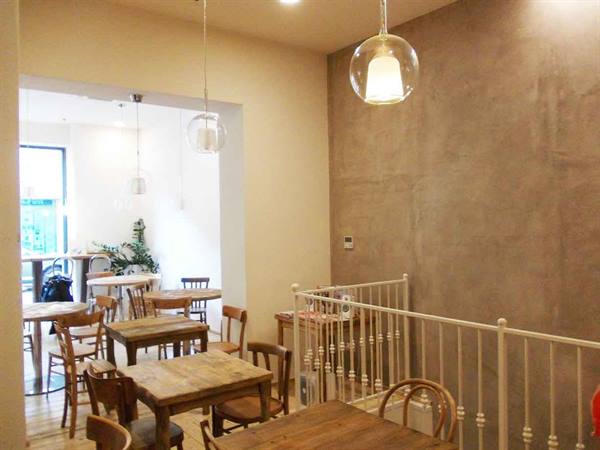 Café interior with wooden tables, bentwood chairs and glass pendant lamps