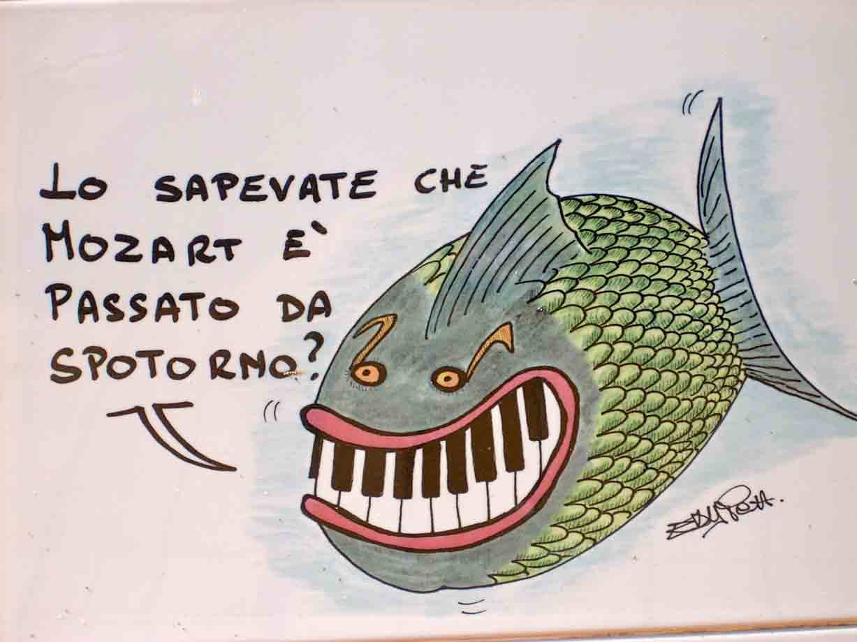 Dessin umoristico: pesce verde con bocca a tastiera pianoforte, scritta su Mozart a Spoleto