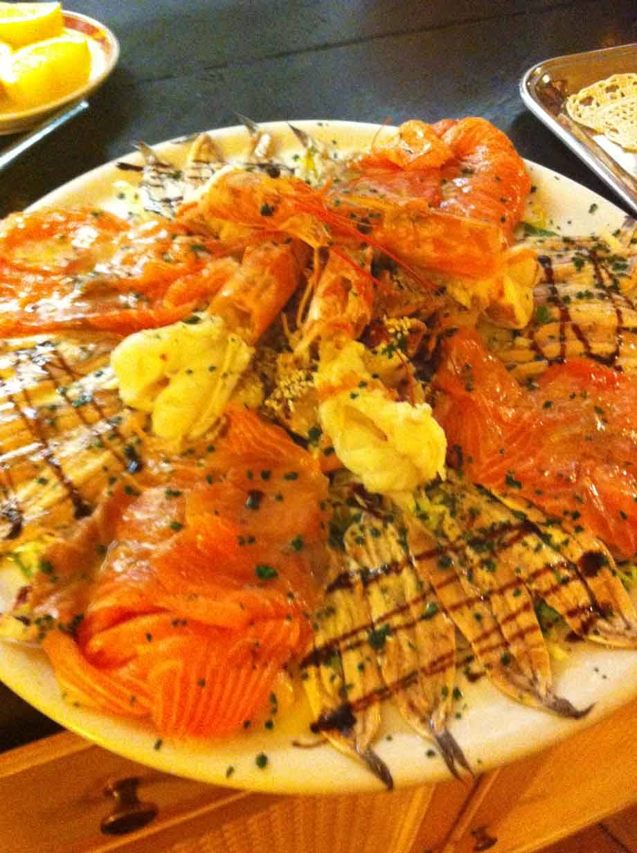 Piatto di frutti di mare con aragoste e salmoni, condito con erbe e salsa