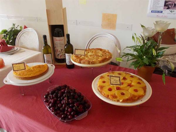 Apple and pineapple cakes with cherries on a set table with white wine