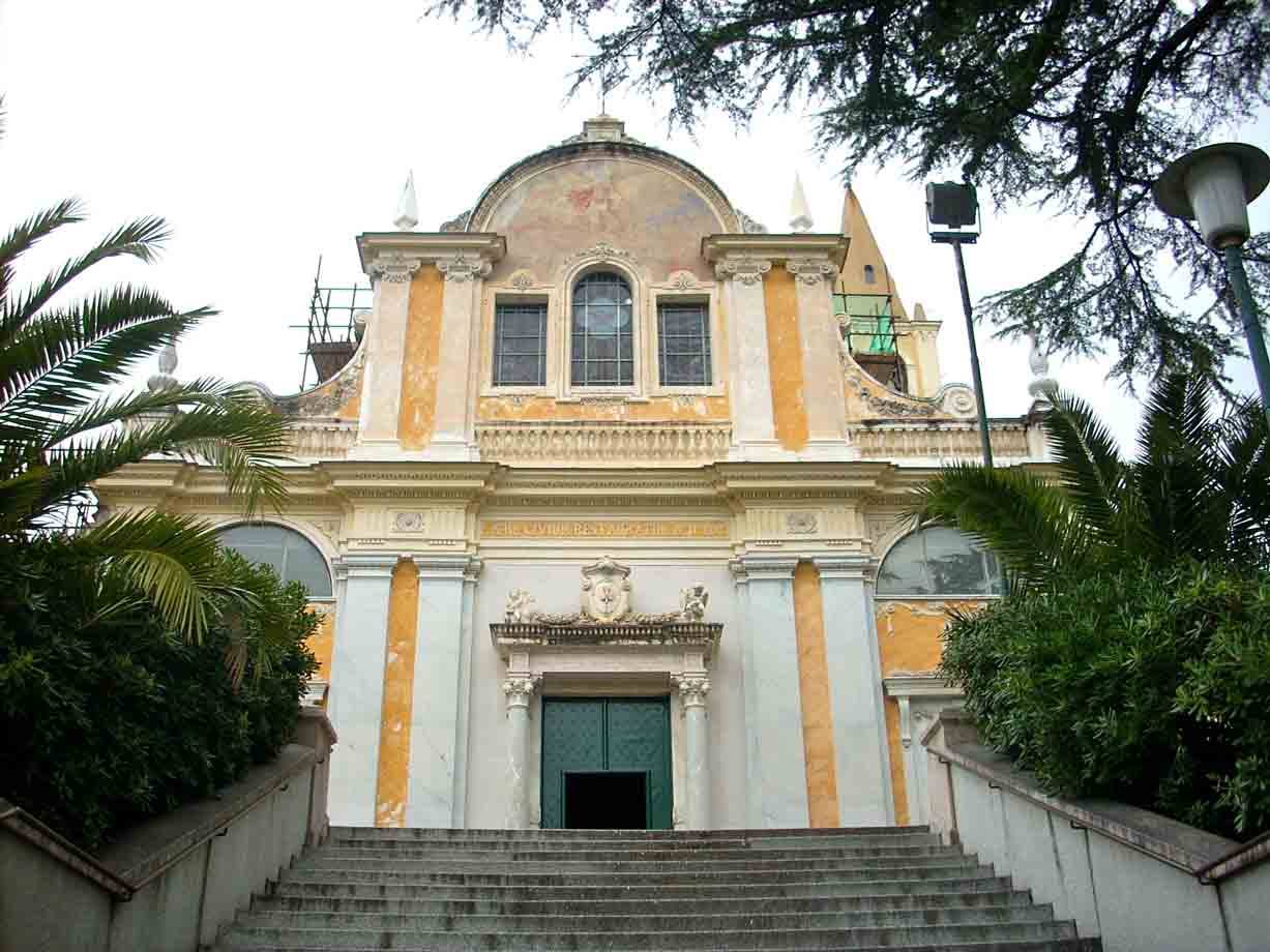 Chiesa barocca ocra con scalinata e palme, facciata affrescata