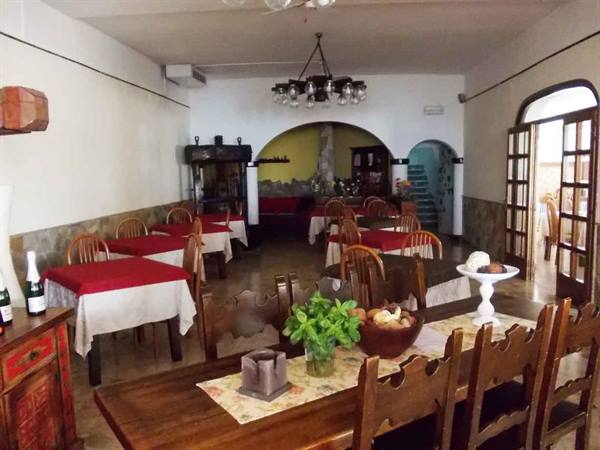 Rustic dining room with wooden tables, red tablecloths and carved chairs