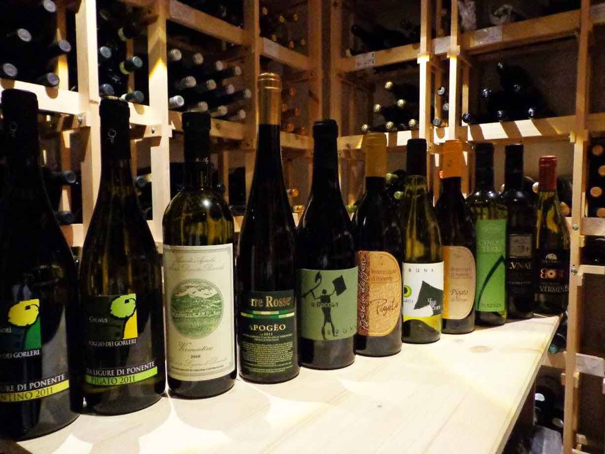 Bottiglie di vino in fila su banco di legno in cantina illuminata