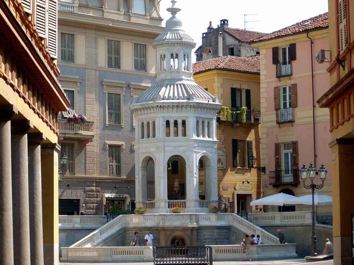 La Bollente ad Acqui Terme, padiglione in marmo bianco tra palazzi colorati