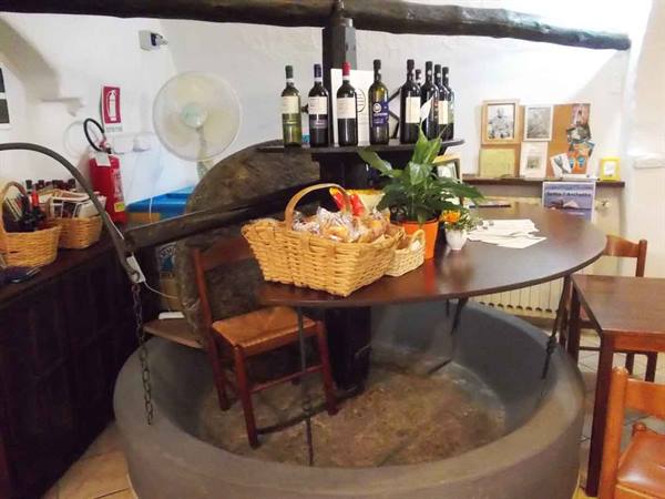 Old stone millstone turned into a table with bread baskets and wine bottles