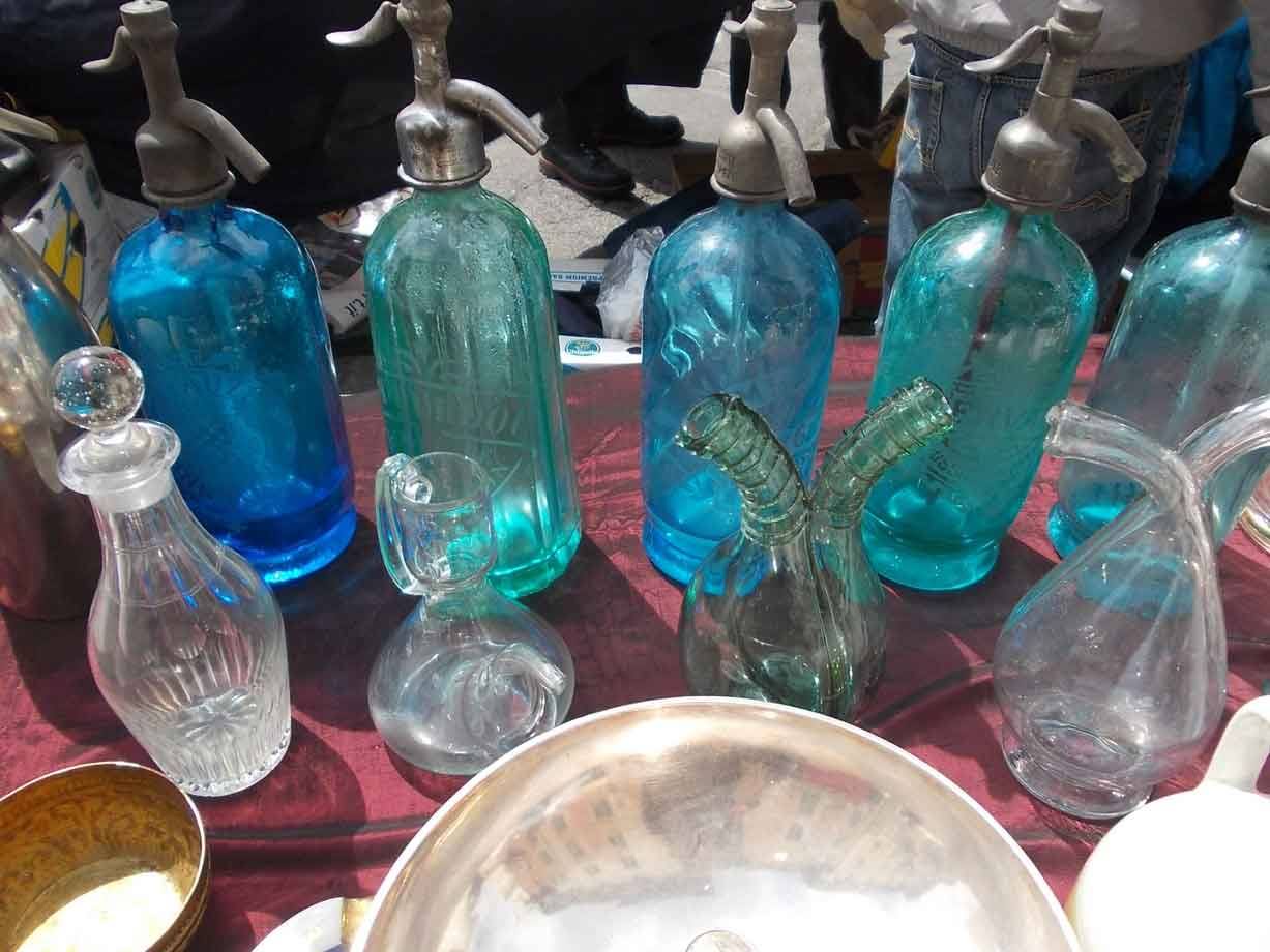 Bottiglie sifon in vetro azzurro e caraffe al mercatino delle pulci