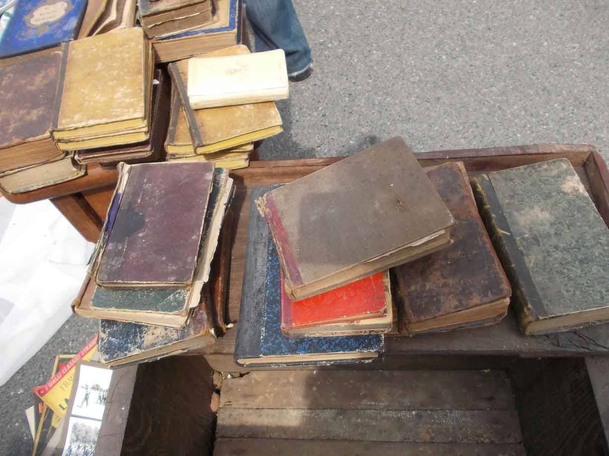 Vecchi libri consumati in vendita su cassa di legno al mercato delle pulci