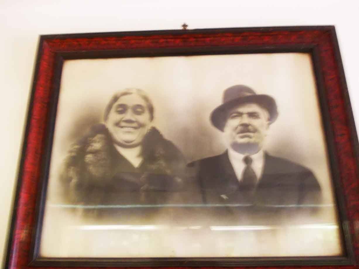Ritratto in bianco e nero di anziana coppia con cappello, cornice rossa