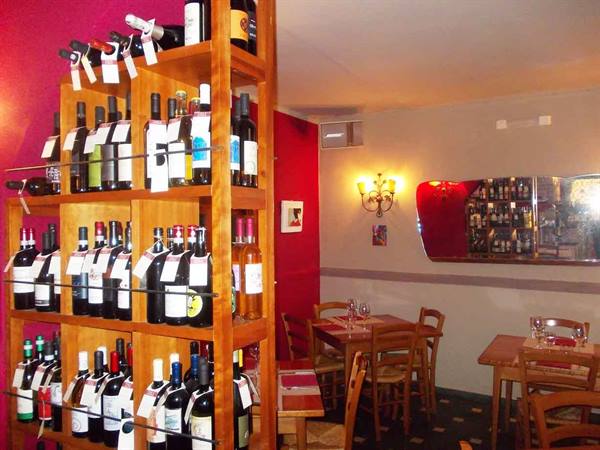 Wine bottle shelf inside a wine bar with wooden tables
